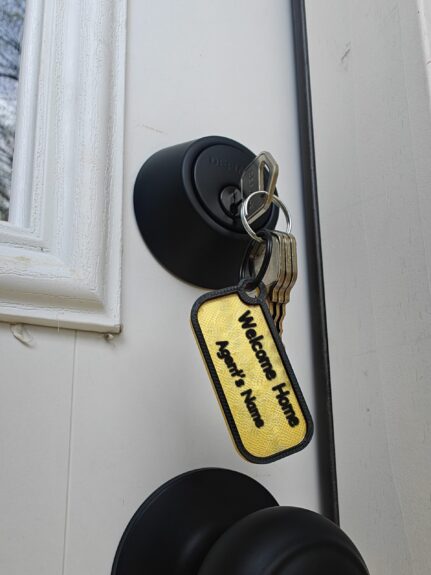 Closing gift keys on a Welcome Home keychain with the agent's name