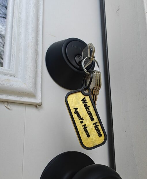 Closing gift keys on a Welcome Home keychain with the agent's name