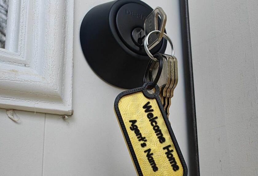 Closing gift keys on a Welcome Home keychain with the agent's name