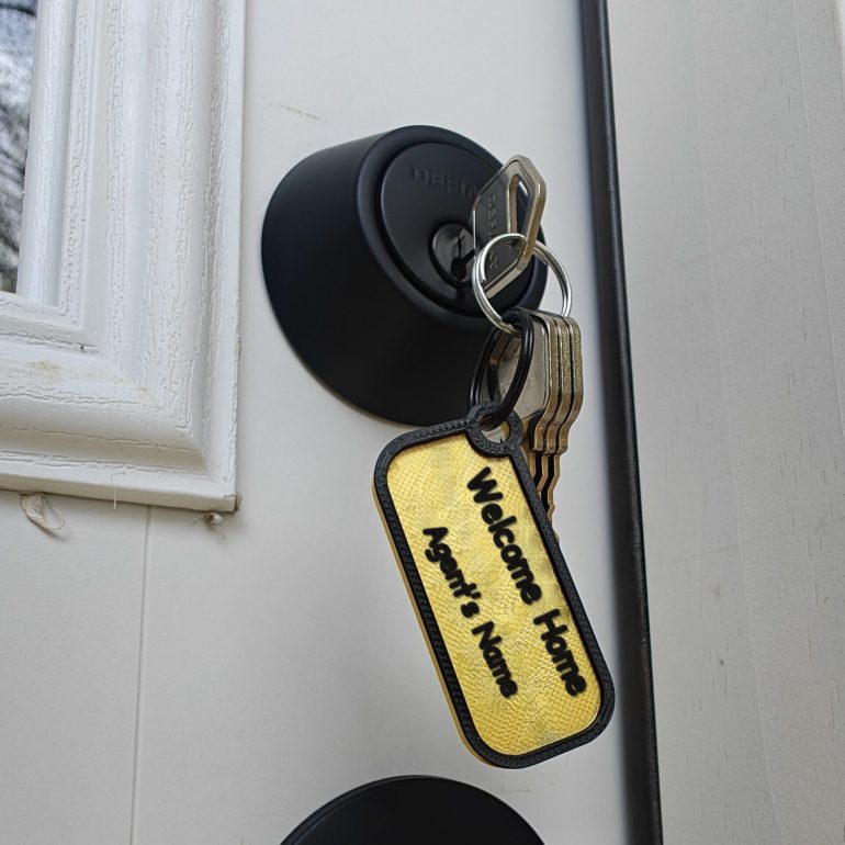 Closing gift keys on a Welcome Home keychain with the agent's name